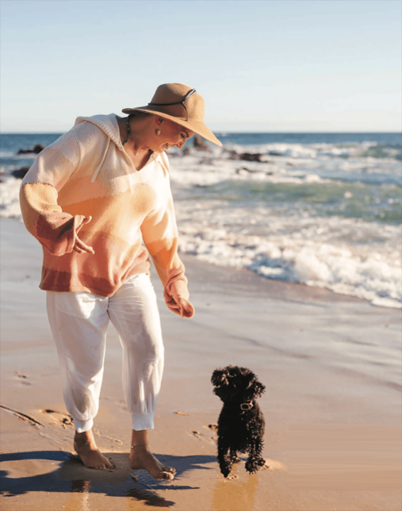 Photo of Jessie running on the beach with her dog